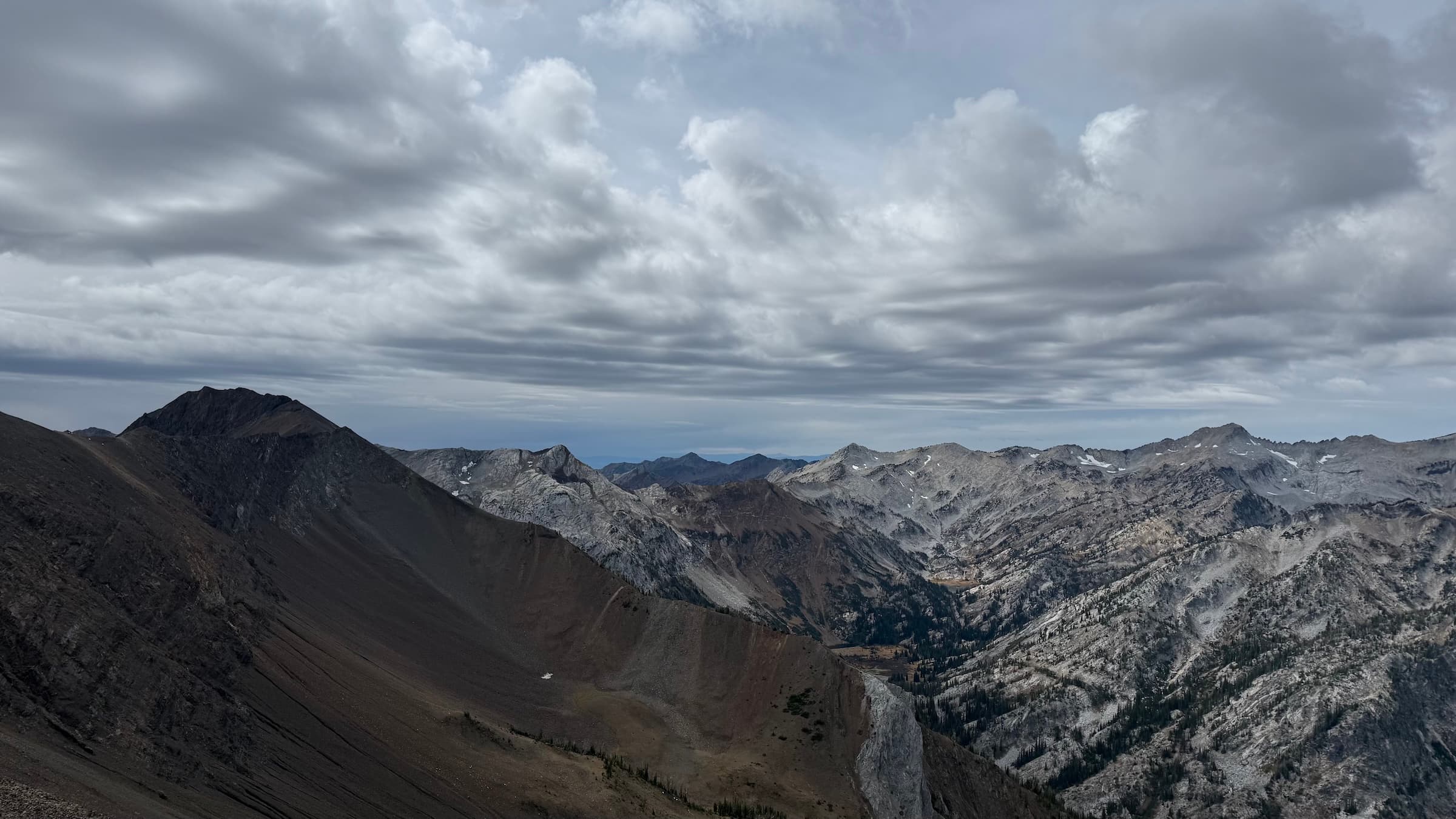 Looking south from a ridge in the Eagle Cap Wilderness under heavy gray clouds moving in over the peaks